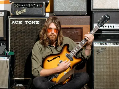 man sitting on floor with guitar